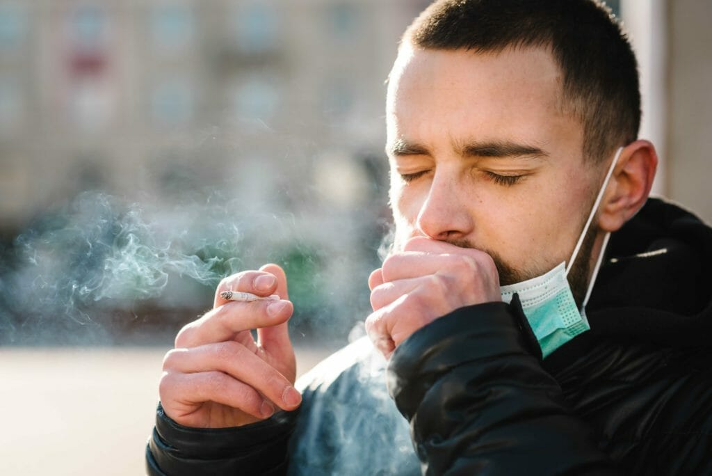 man coughing from marijuana smoke depicting the benefits of quitting