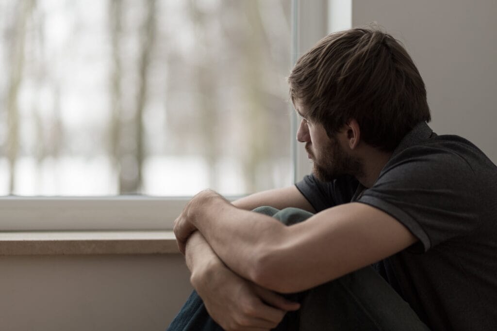 depressed man staring out the window